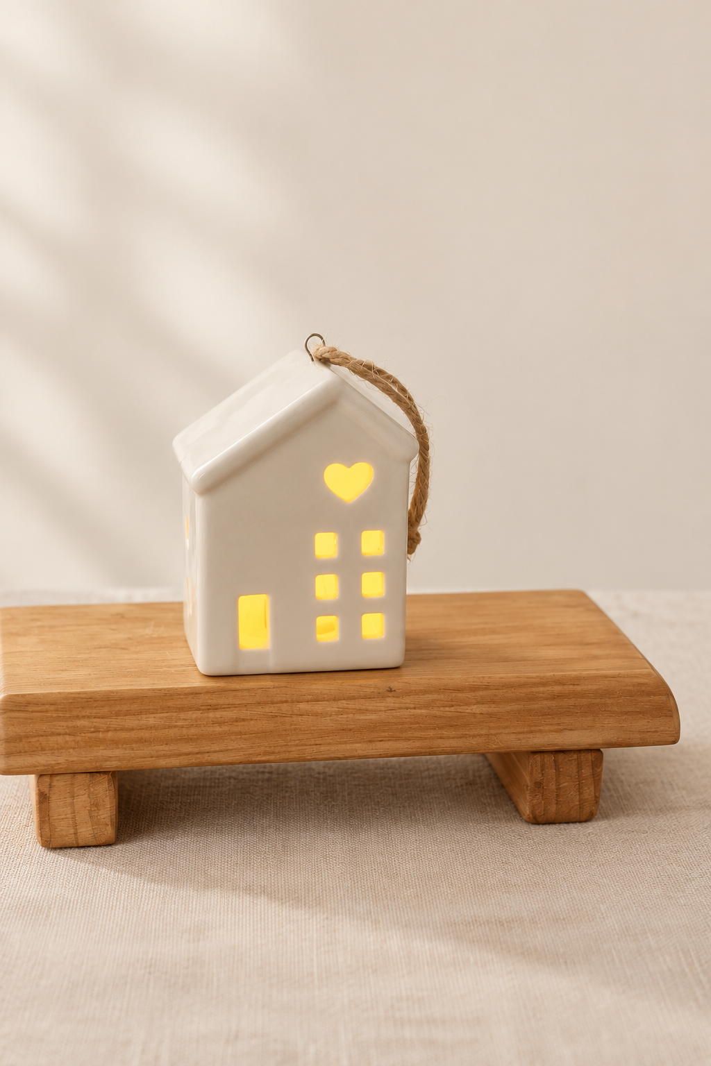 Casita de cerámica iluminada sobre base de madera