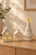 Dos casitas iluminadas y árbol de cerámica en un ambiente de hogar
